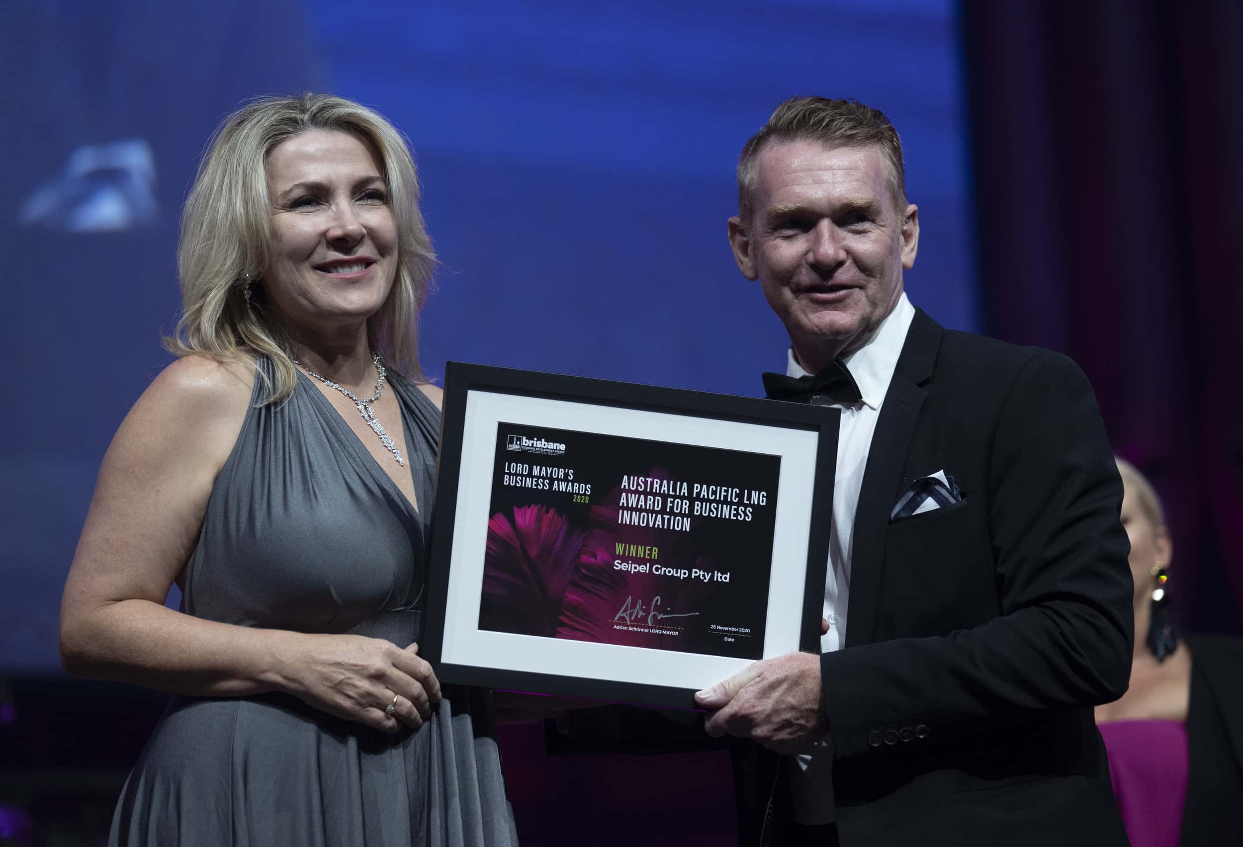 Tracey Seipel and Patrick Coll on stage at the Lord Mayor's Business Awards, accepting award for Seipel Group, winner of the Australia Pacific LNG Award for Business Innovation.